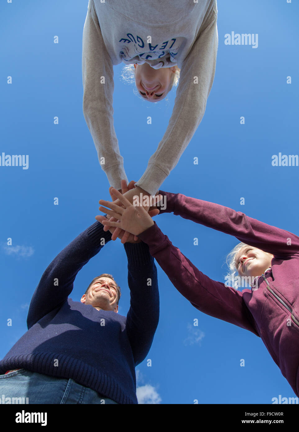 A family holding hands against a blue sky Stock Photo - Alamy