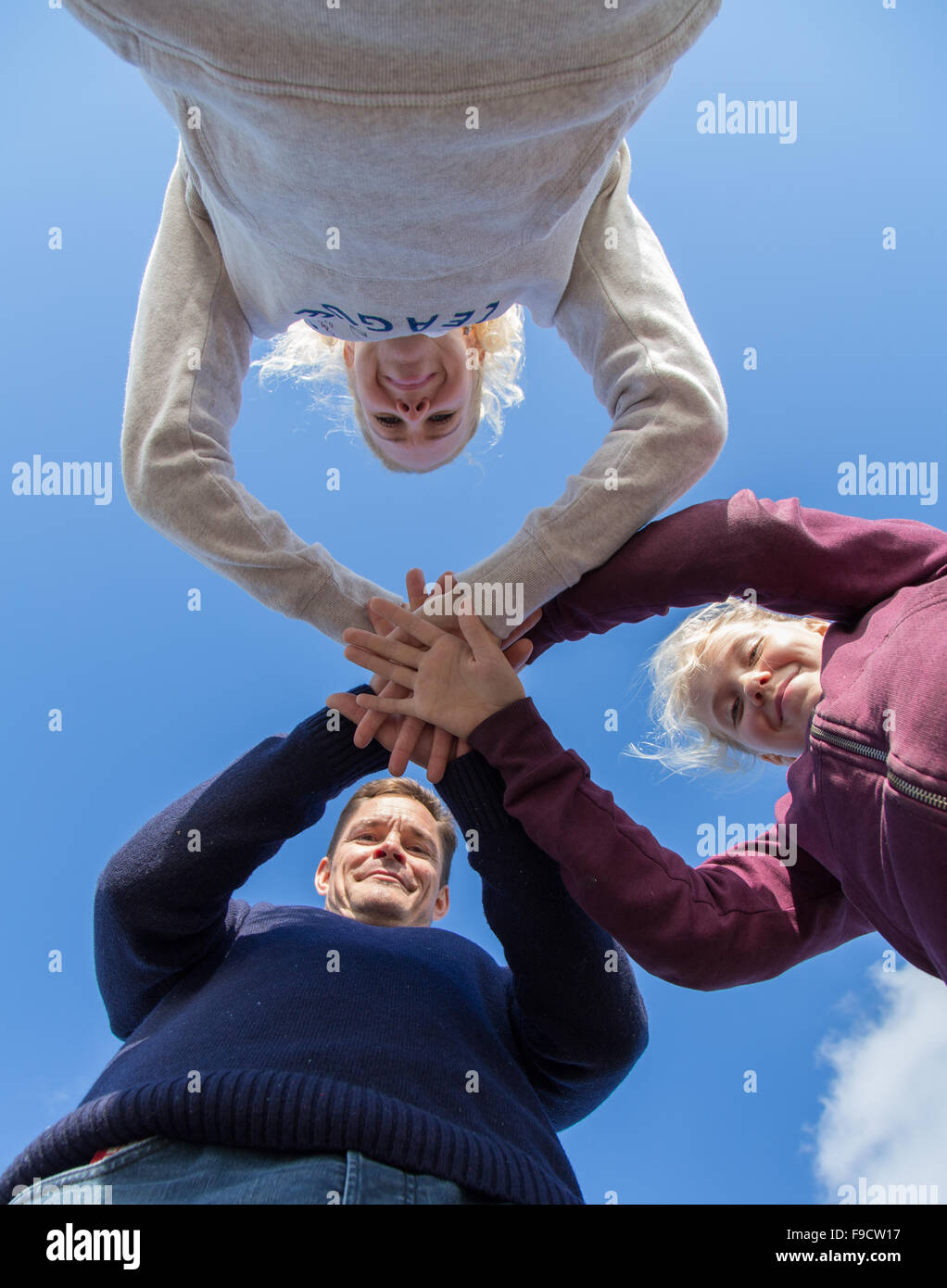 A family holding hands against a blue sky Stock Photo - Alamy