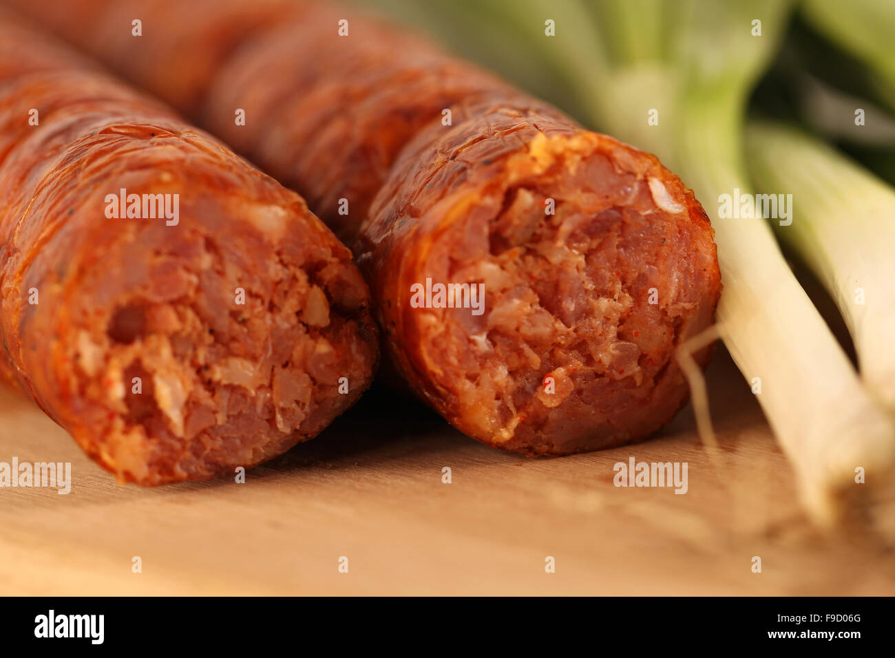 Delicious pork sausage with onion on wooden plate Stock Photo