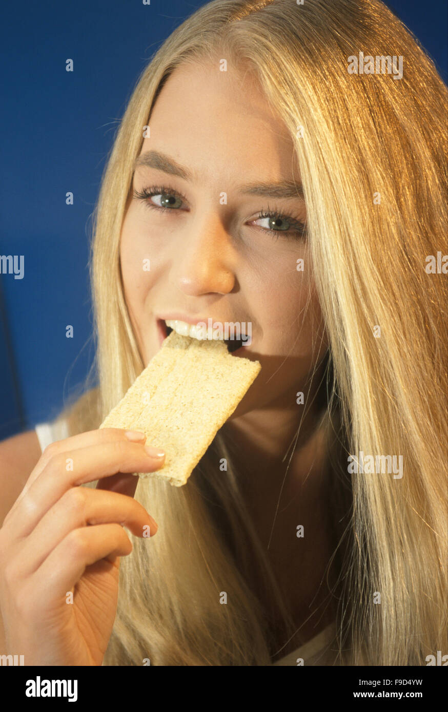 Young woman eating cracker Stock Photo Alamy