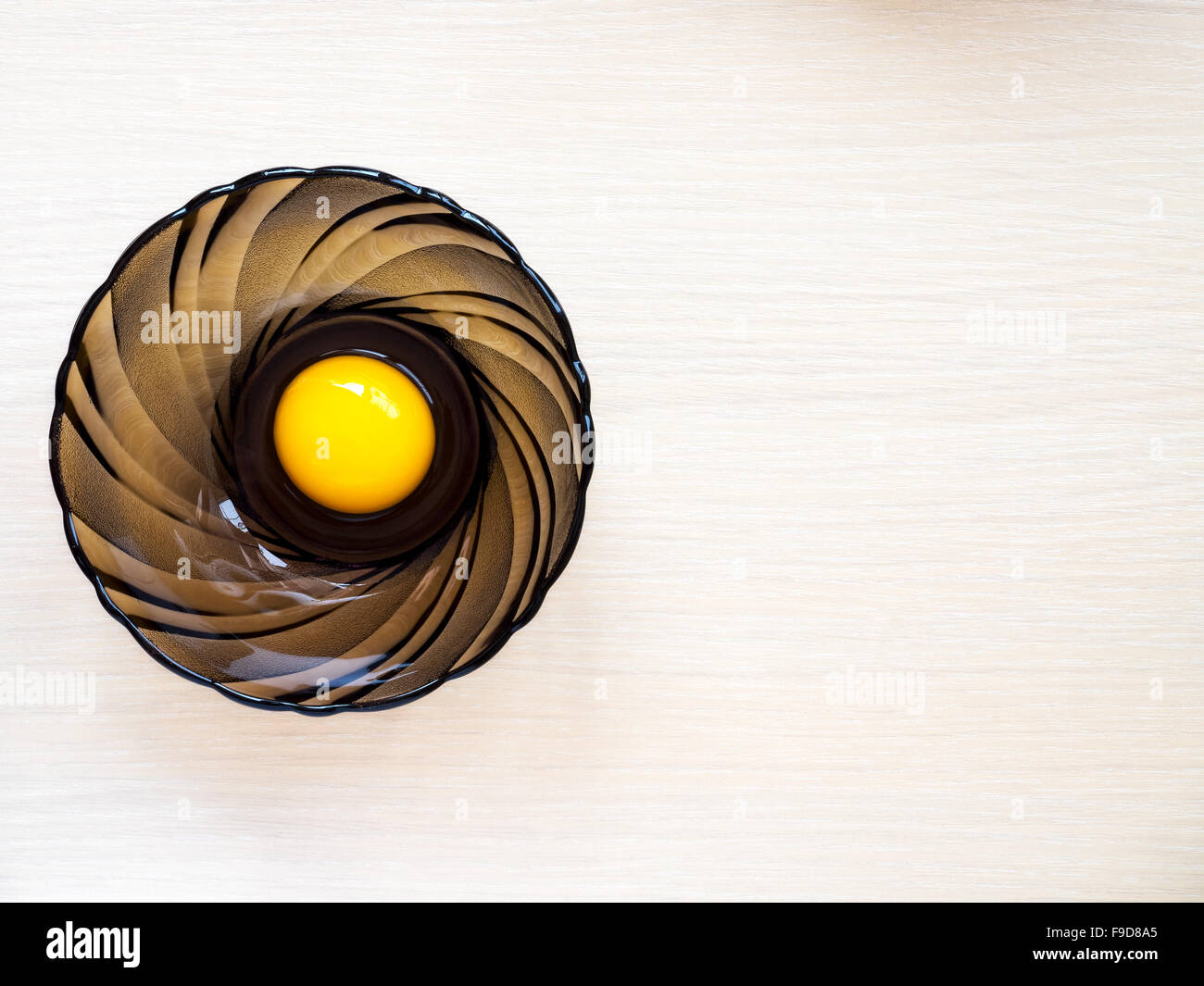Top view on the glass cup with egg on the wooden table Stock Photo