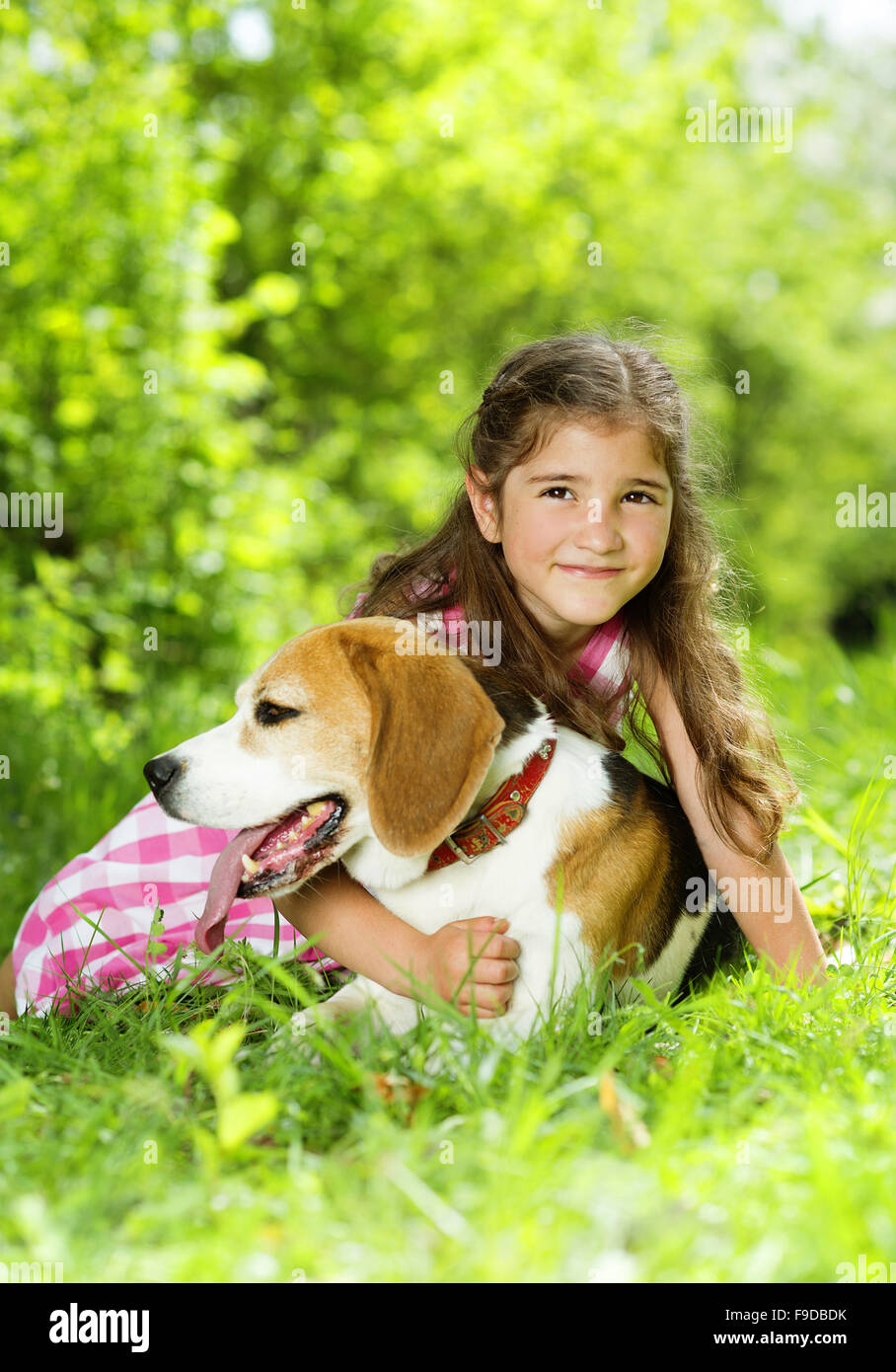 Cute little girl is playing with her dog in the green park Stock Photo ...