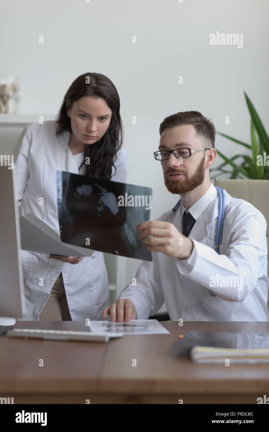 Doctors discussing intestines xray at medical office Stock Photo