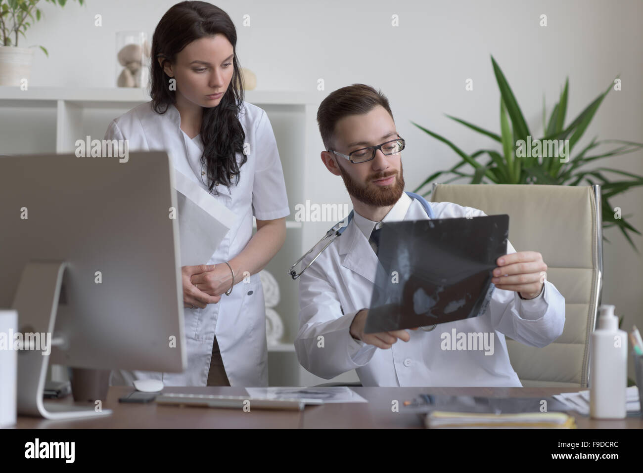Doctors discussing intestines xray at medical office Stock Photo