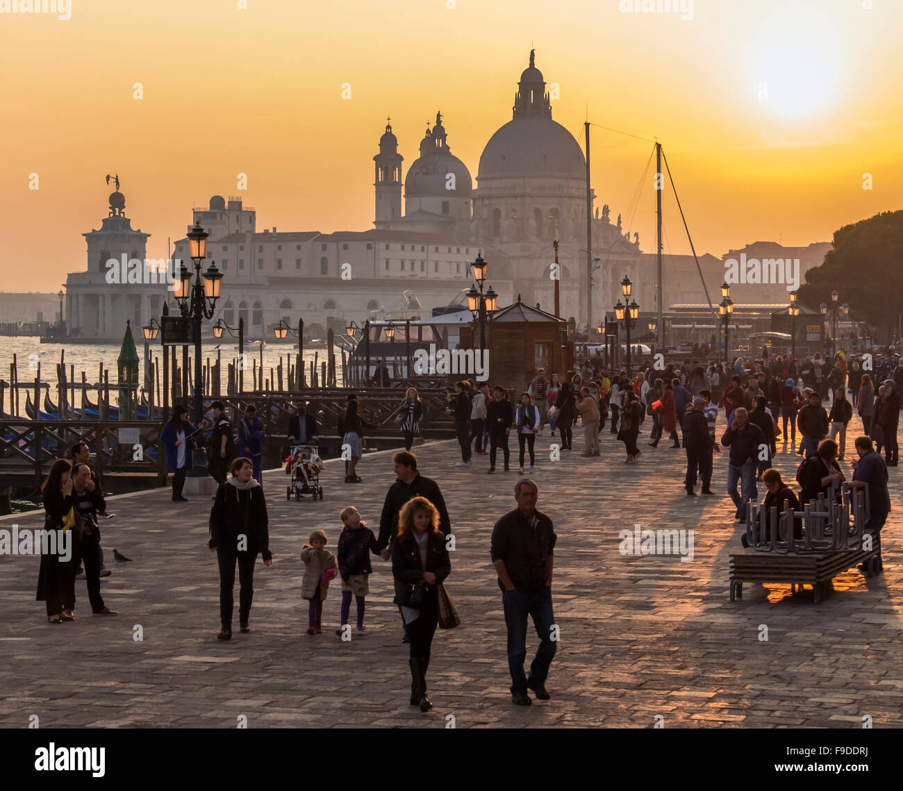 Venice, Italy, Sunset view of Basilica di Santa Maria della Salute and people enjoying the golden waterfront light Stock Photo