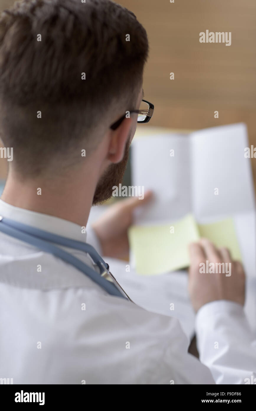 Doctor working with test results of his patient at office Stock Photo