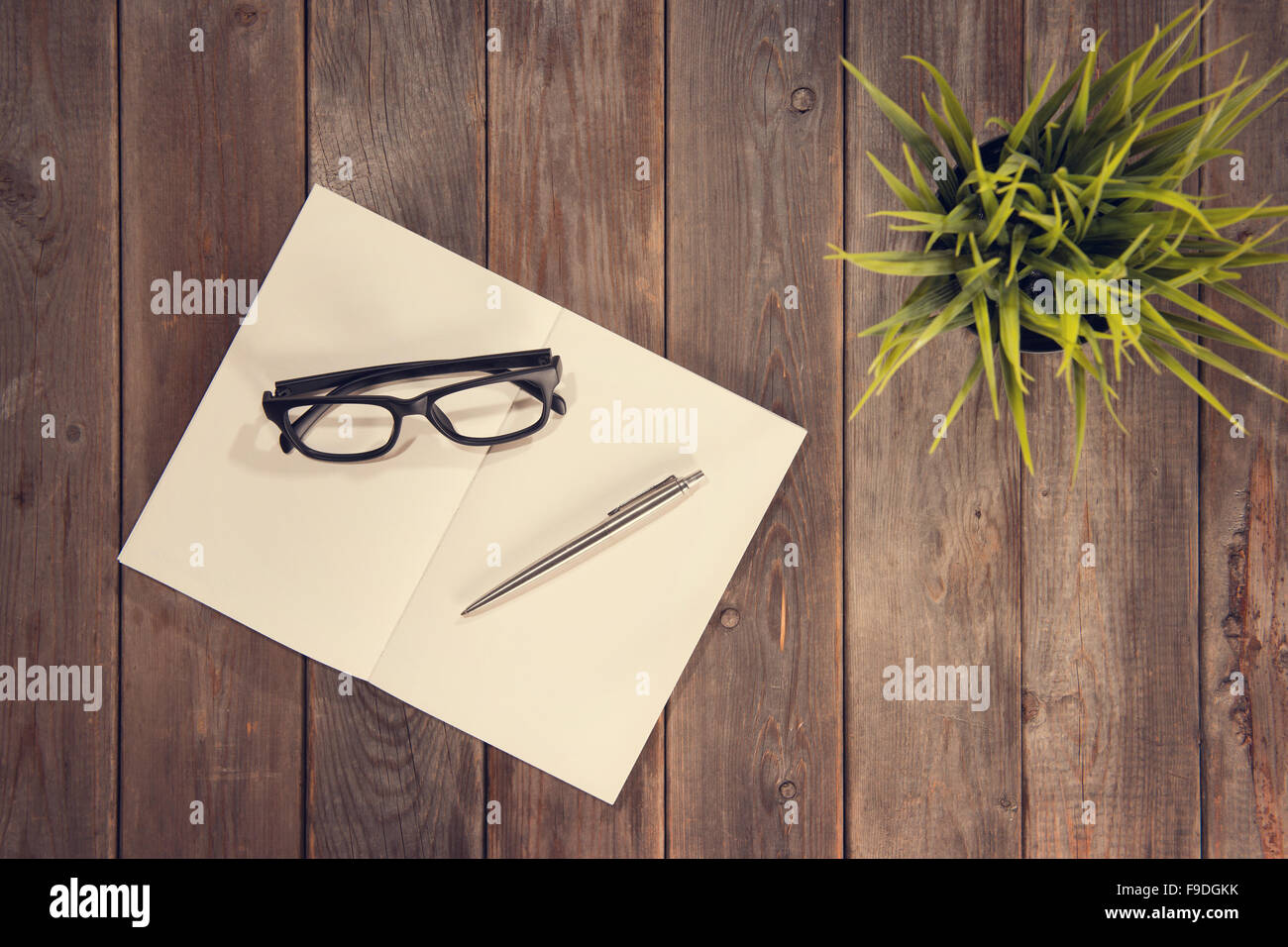 Top view working desk with diary book, eyeglasses, pen and plant pot.  Wooden table background with copy space in vintage toned Stock Photo - Alamy