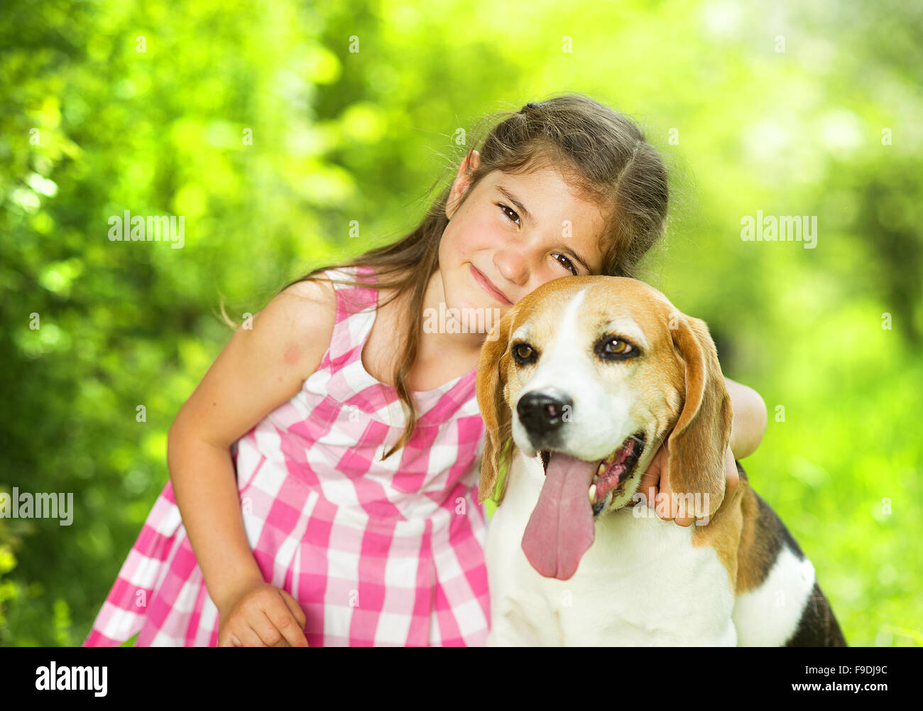Cute little girl is playing with her dog in the green park Stock Photo ...