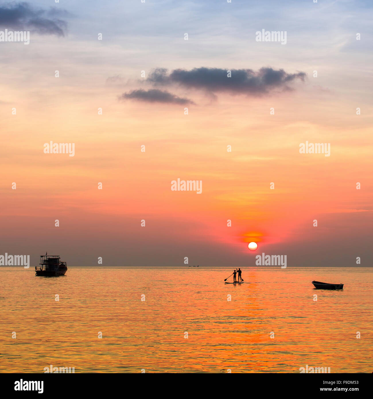 Couple on the boards in the sea during beautiful sunset in the Gulf of Thailand. Stock Photo