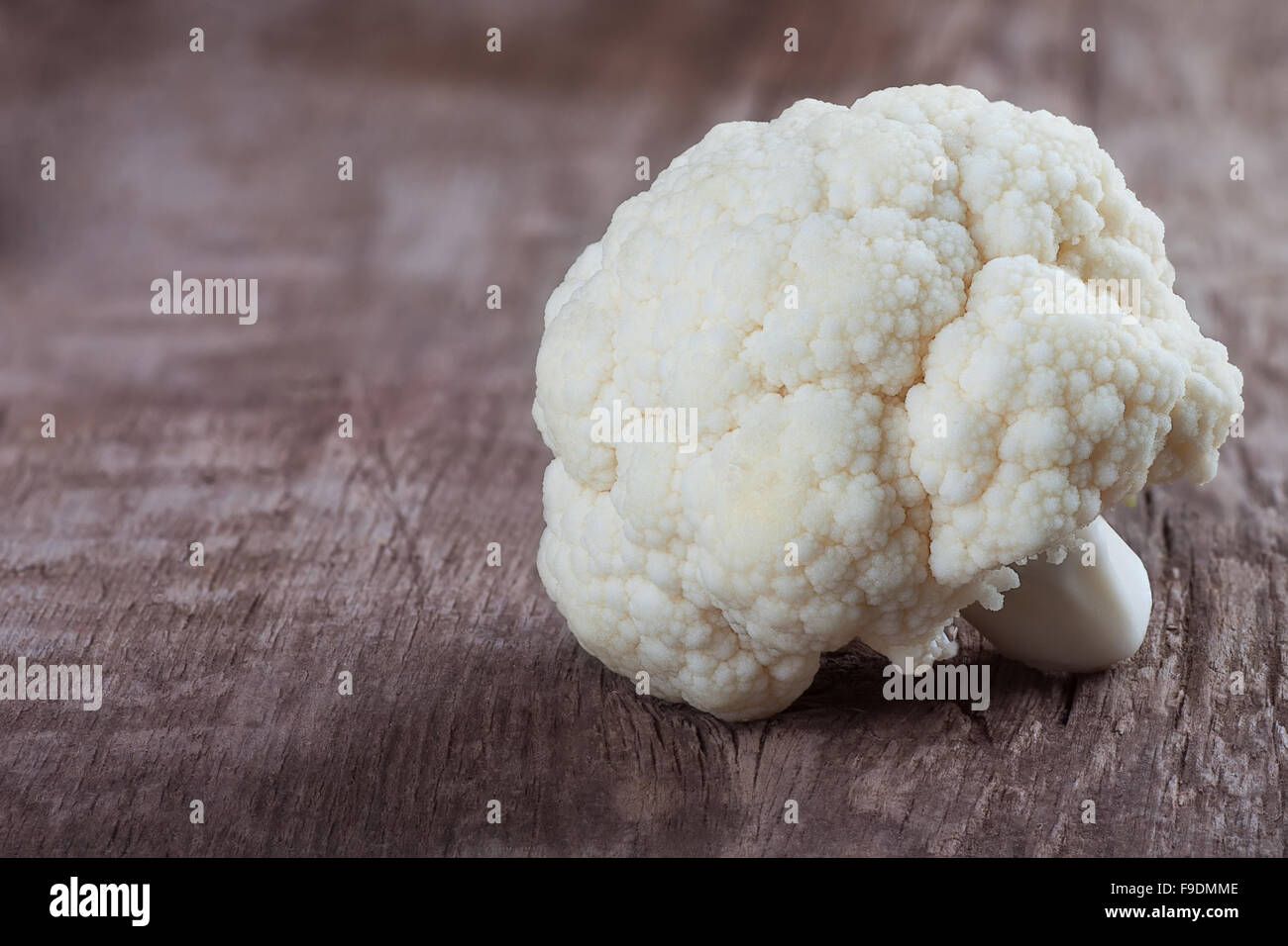 one inflorescence of organic cauliflower on wooden background Stock Photo
