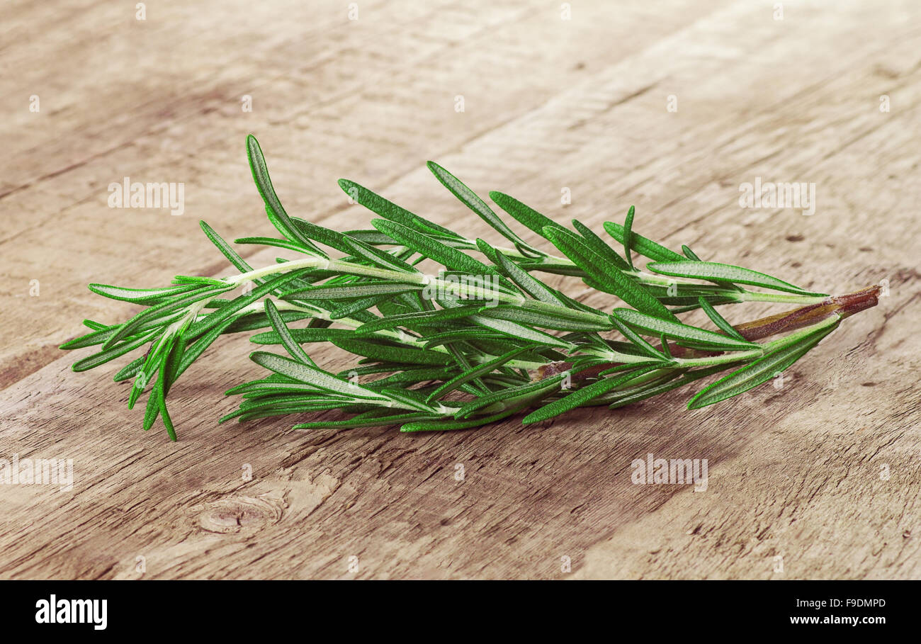 fresh rosemary branch on a wooden background Stock Photo