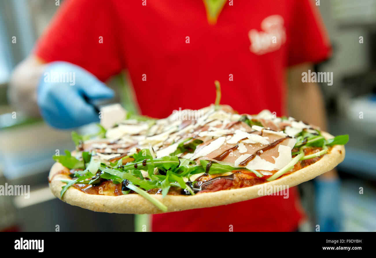 Hamburg, Germany. 24th May, 2013. An employee of Joey's Pizza Delivery holds up pizza in Hamburg, Germany, 24 May 2013. At the moment, the company, which was founded in 1988, has 130 franchise partners throughout Germany. Photo: SVEN HOPPE/dpa/Alamy Live News Stock Photo