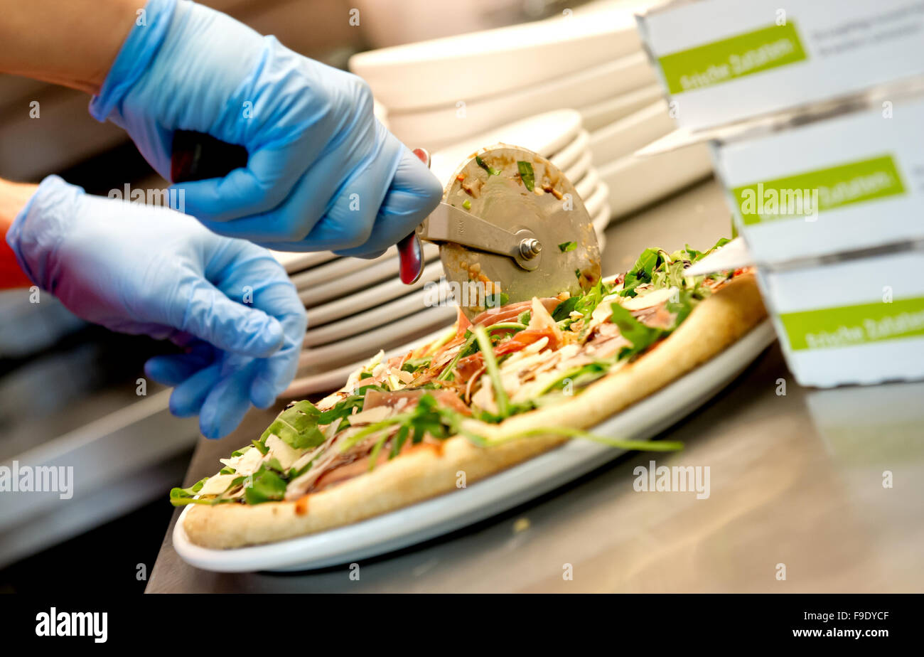 Hamburg, Germany. 24th May, 2013. An employee of Joey's Pizza Delivery slices a pizza in Hamburg, Germany, 24 May 2013. At the moment, the company, which was founded in 1988, has 130 franchise partners throughout Germany. Photo: SVEN HOPPE/dpa/Alamy Live News Stock Photo