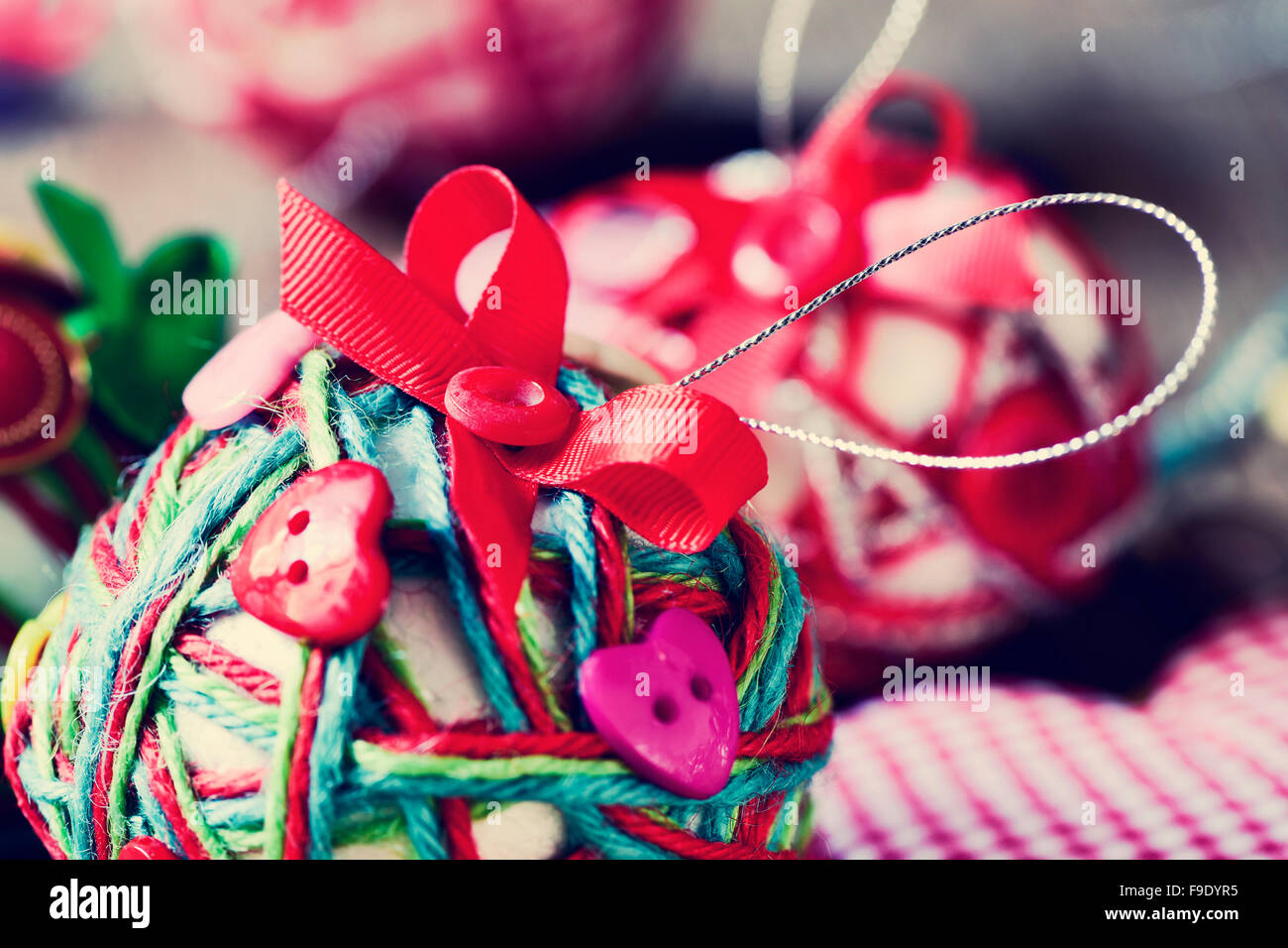 closeup of some different handmade christmas balls, made with string, ribbon and buttons, with a filter effect Stock Photo