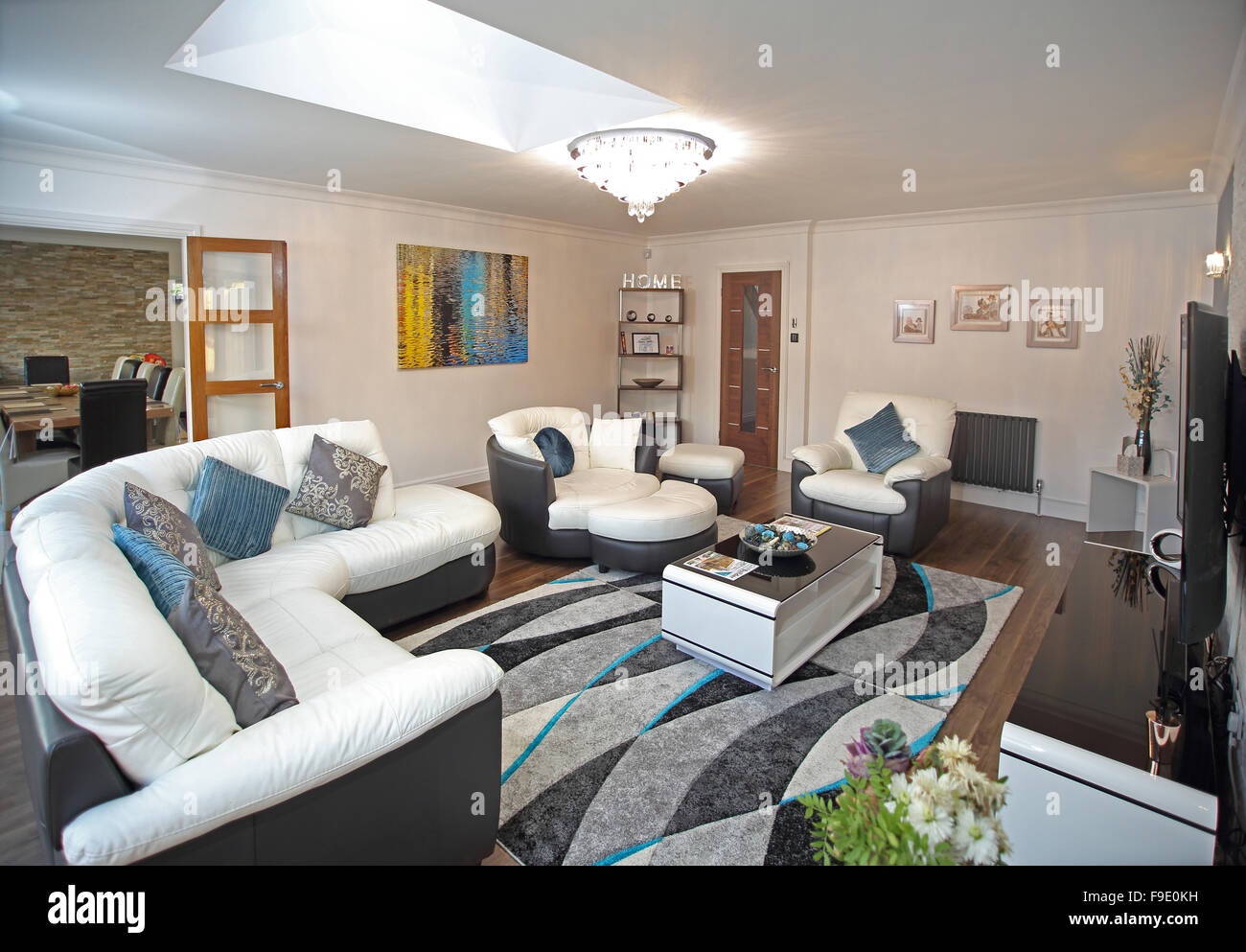 The living room of a newly refurbished house with two-tone leather sofas and double doors to dining room Stock Photo