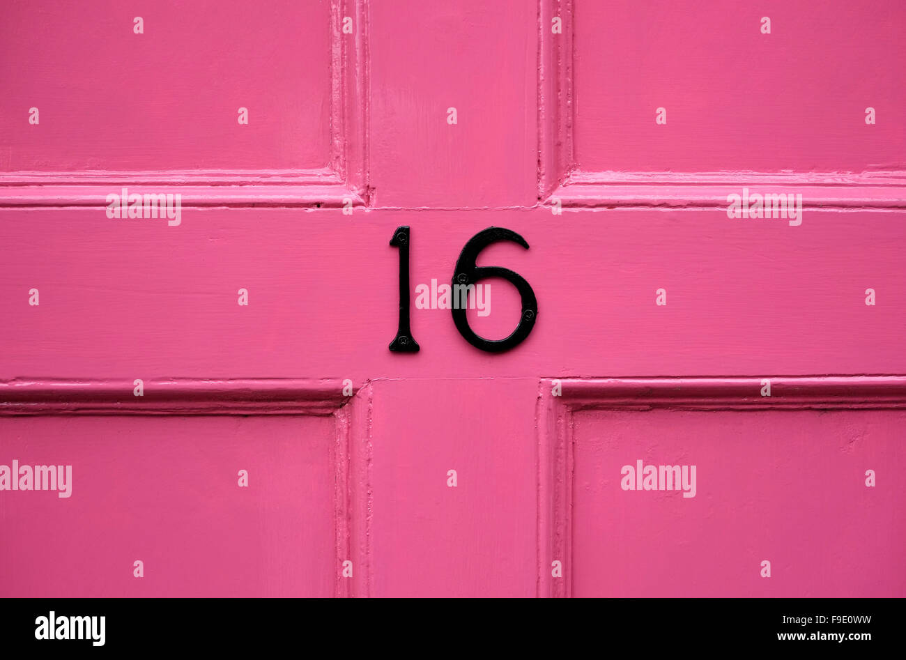 sixteen on pink painted front door Stock Photo