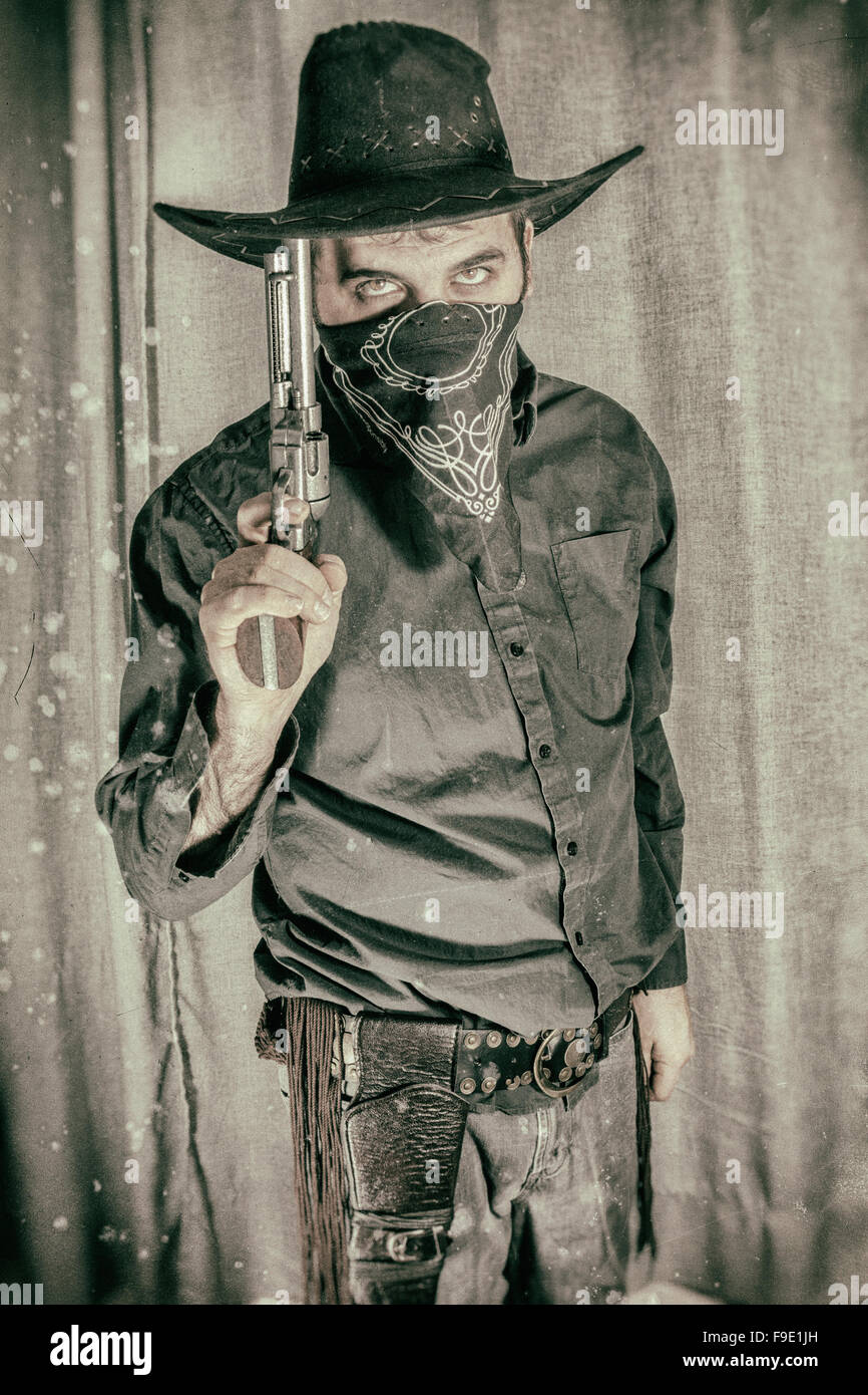 Cowboy gunslinger holding gun up hires stock photography and images