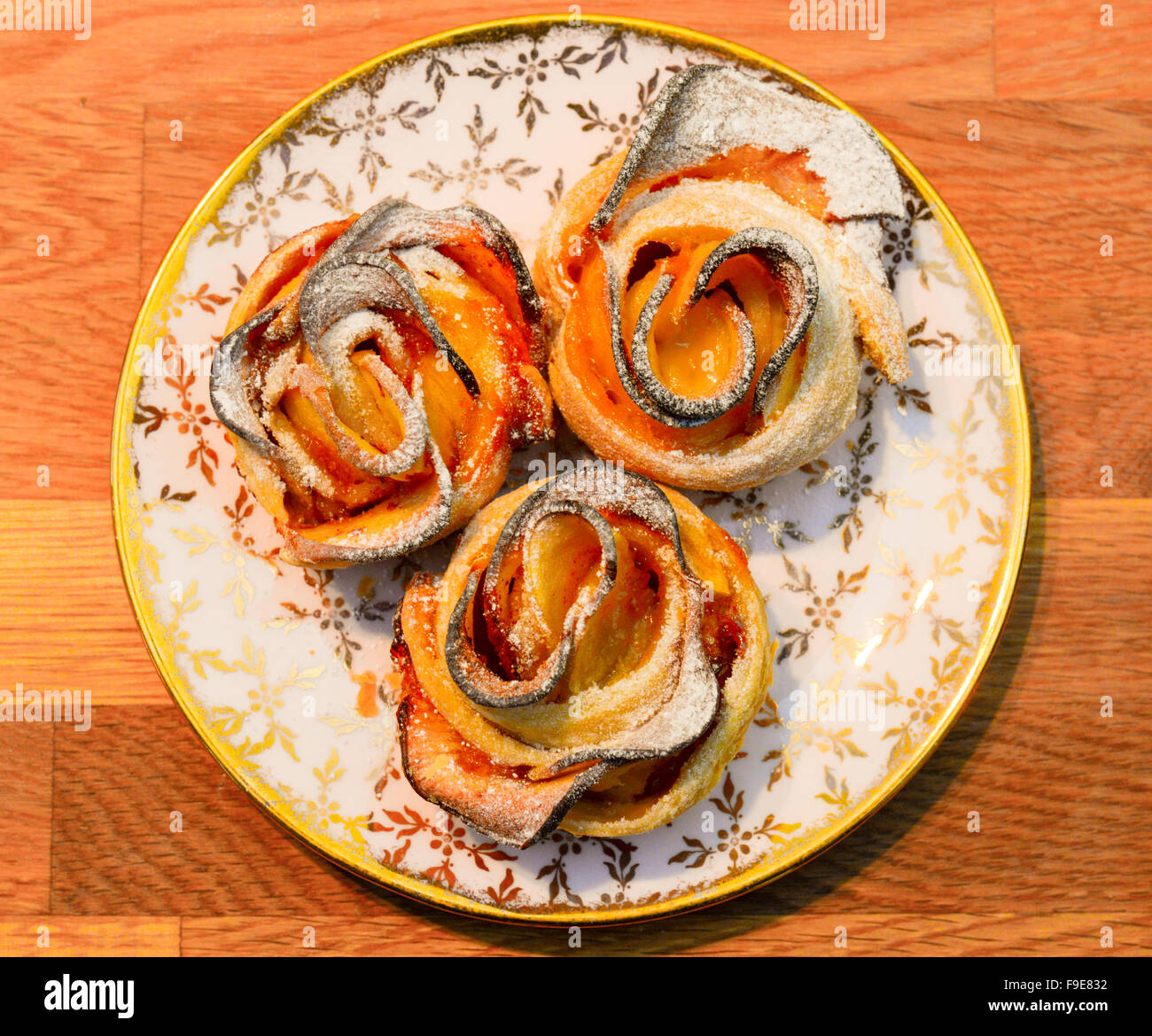 Three apple rose pies on a plate. Stock Photo