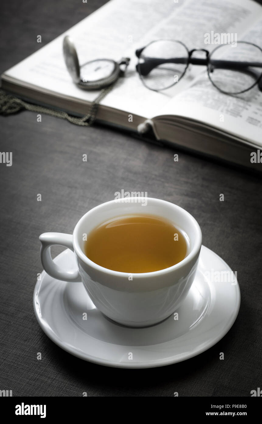 Cup of tea and book on wooden table, close up Stock Photo