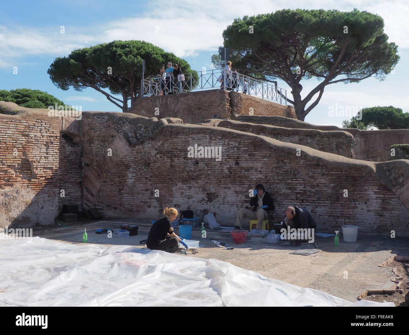 Team of three archaeologists working on a mosaic floor in Ostia Antica, near Rome, Italy Stock Photo