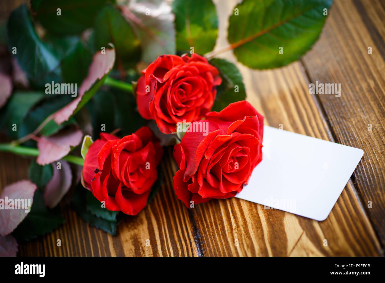A stylish decoration of red rose flowers, ribbons on a shiny black