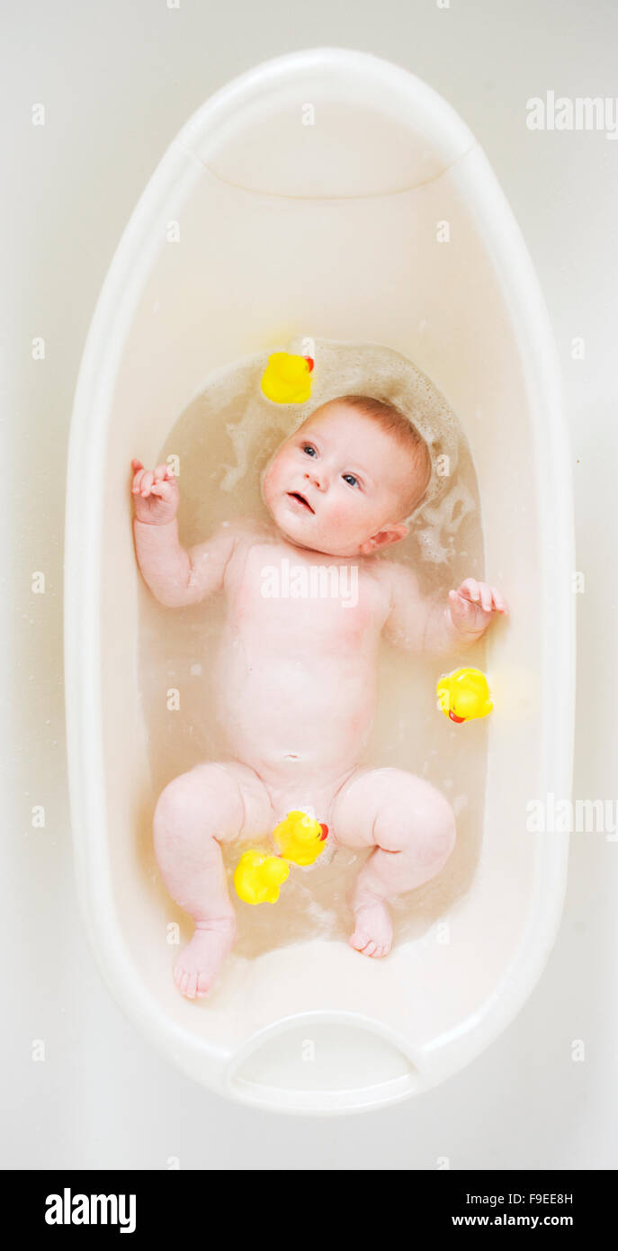 baby boy girl having fun in the tub with rubber ducks at bath time. Stock Photo