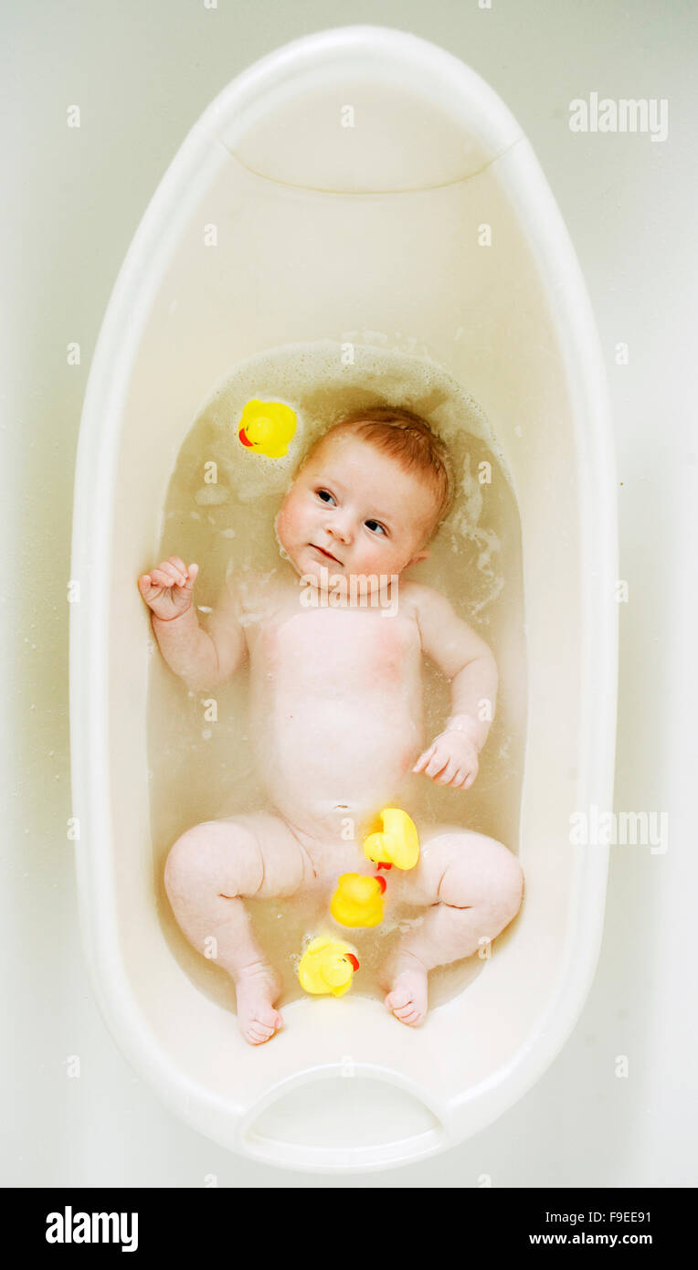 baby boy girl having fun in the tub with rubber ducks at bath time. Stock Photo