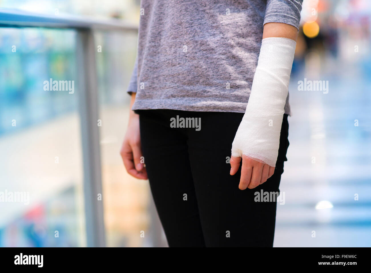 Unrecognizable woman with broken arm inside of a shopping center Stock Photo