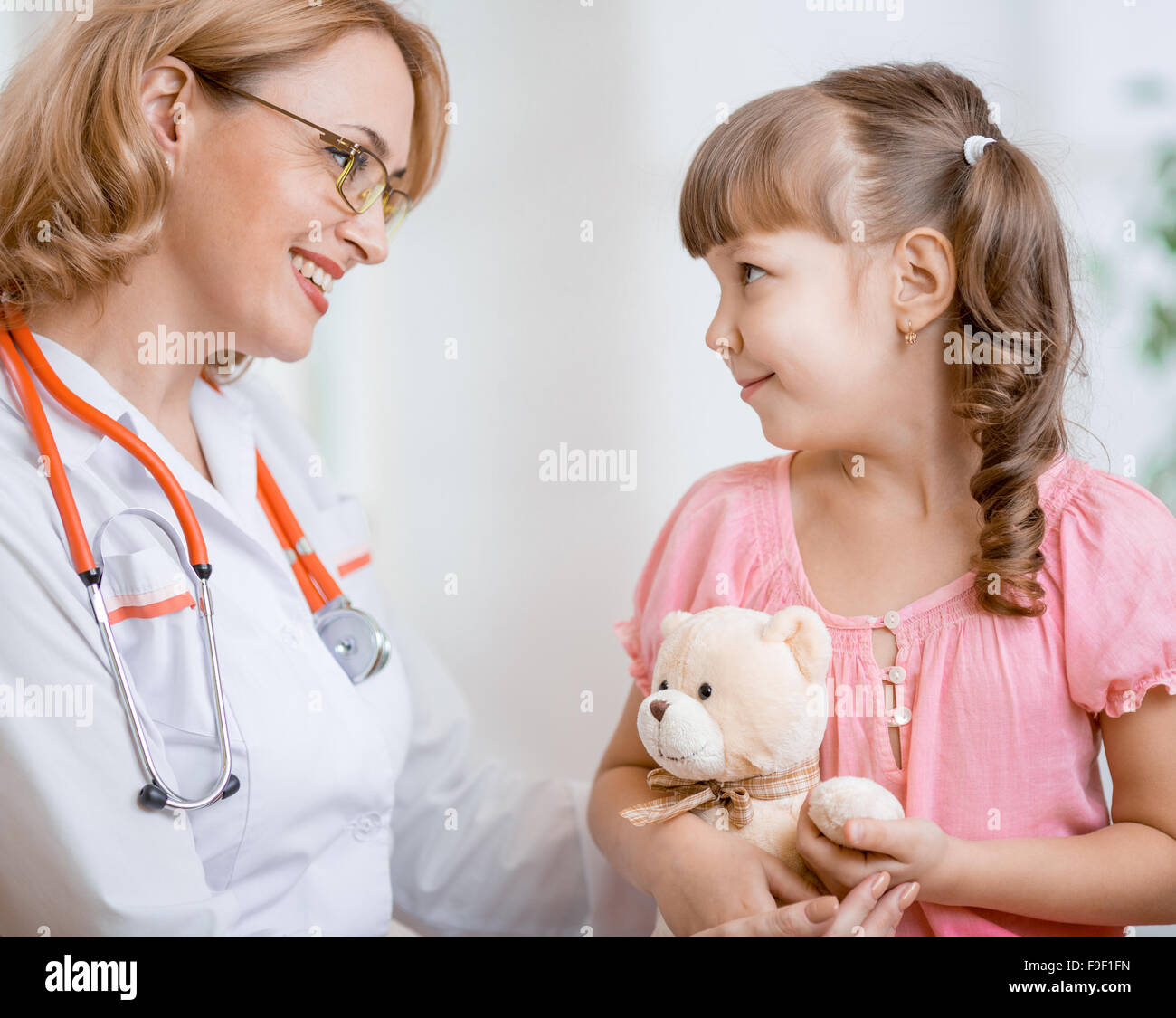 Pediatrician doctor talking with kid Stock Photo