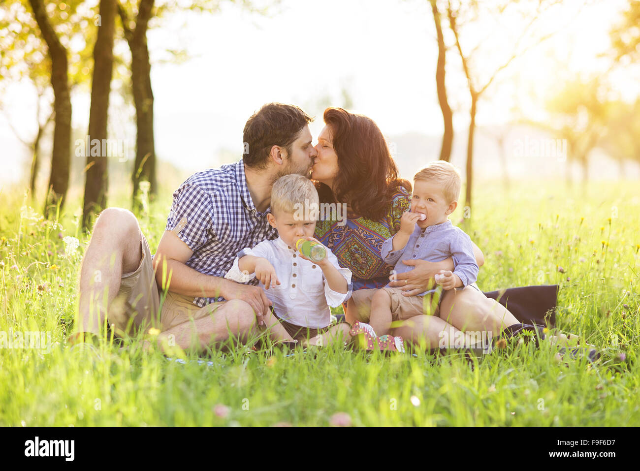 Happy young family spending time together outside in green nature. Stock Photo