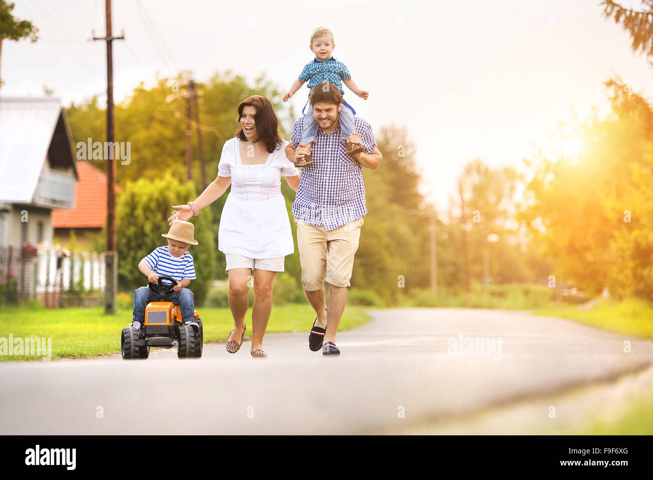 Happy young family having fun outside on the street of a village Stock Photo