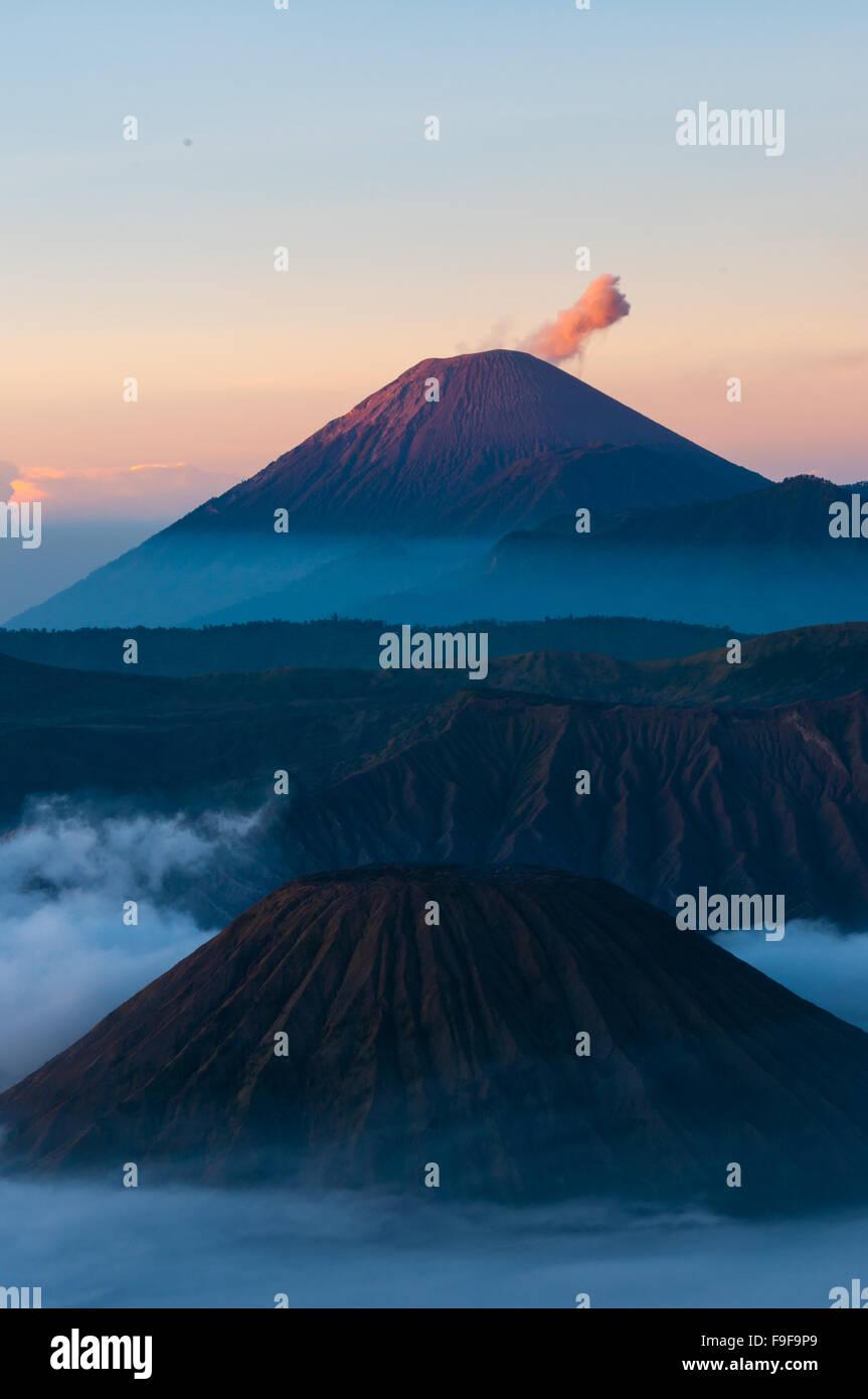 Mountain in mist and smoking Volcano Bromo Stock Photo