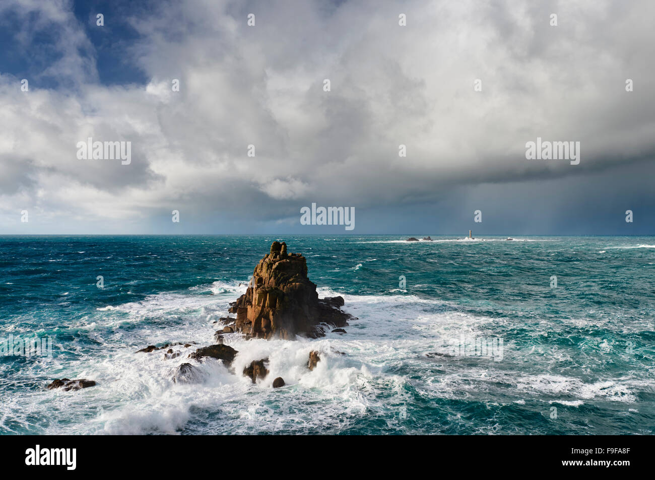 Huge seas crash around the Armed Knight rock formation at Lands End Cornwall Stock Photo