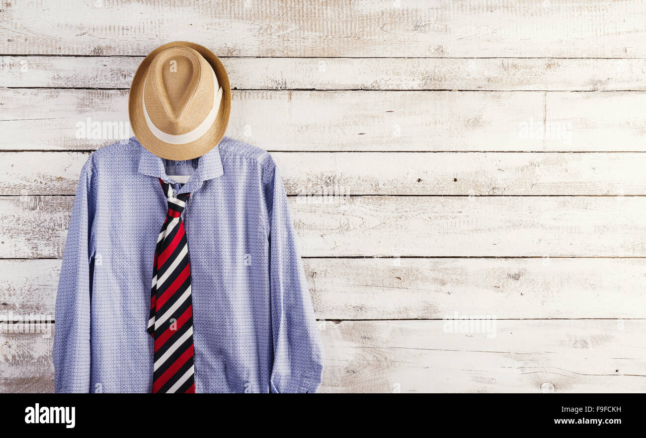 Fathers day composition of shirt, tie and hat hang on wooden wall background. Stock Photo