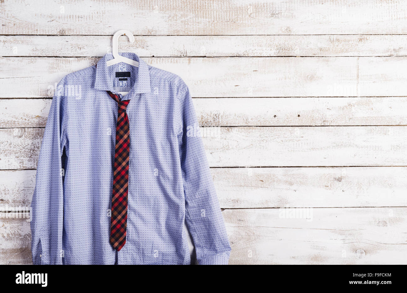 Fathers day composition of shirt and tie hang on wooden wall background. Stock Photo