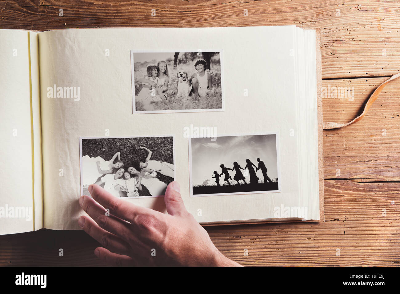 Photo album with black and white family pictures. Studio shot on wooden background. Stock Photo