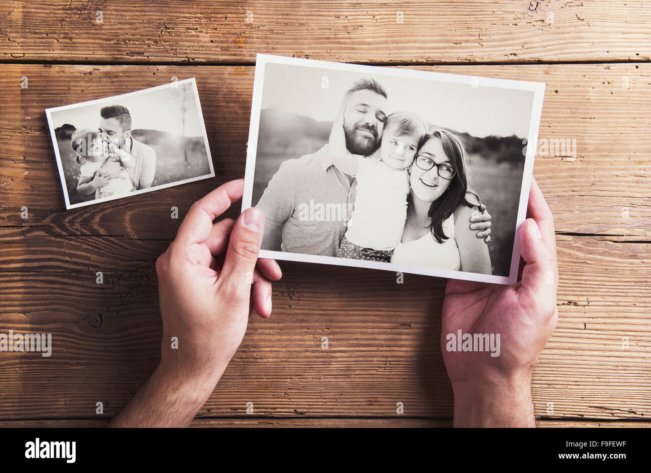 Black and white family photos laid on a table. Studio shot on wooden background. Stock Photo