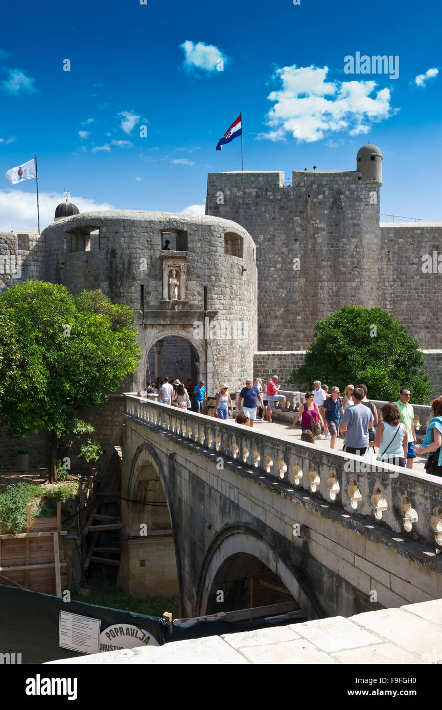 Tourists crossing a bridge to enter the Pile Gate in the Fortress in the Old Town, Dubrovnik, Croatia. Stock Photo