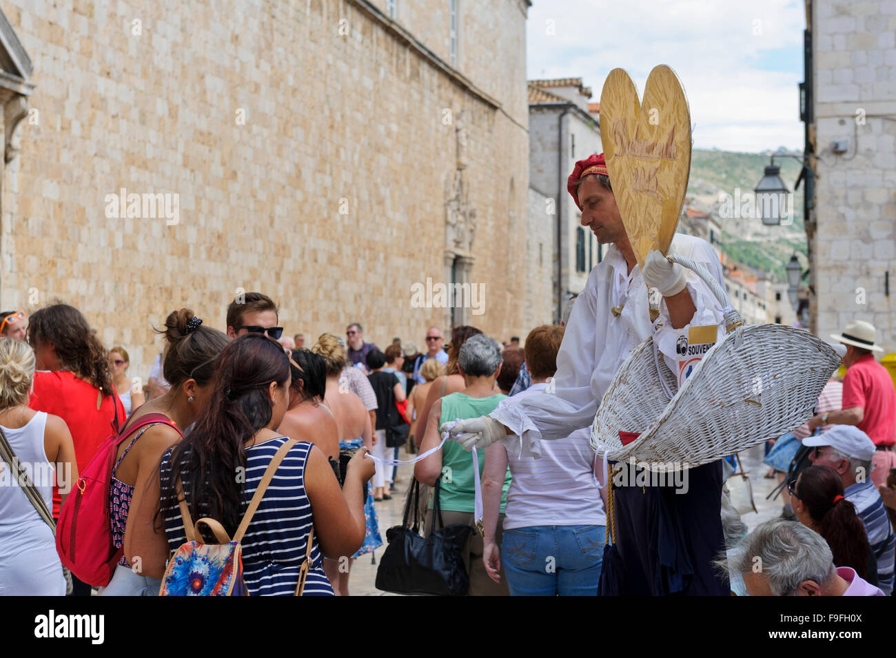 A man holding a heart shape red cardboard and selling necklaces to tourists, Dubrovnik, Croatia. Stock Photo
