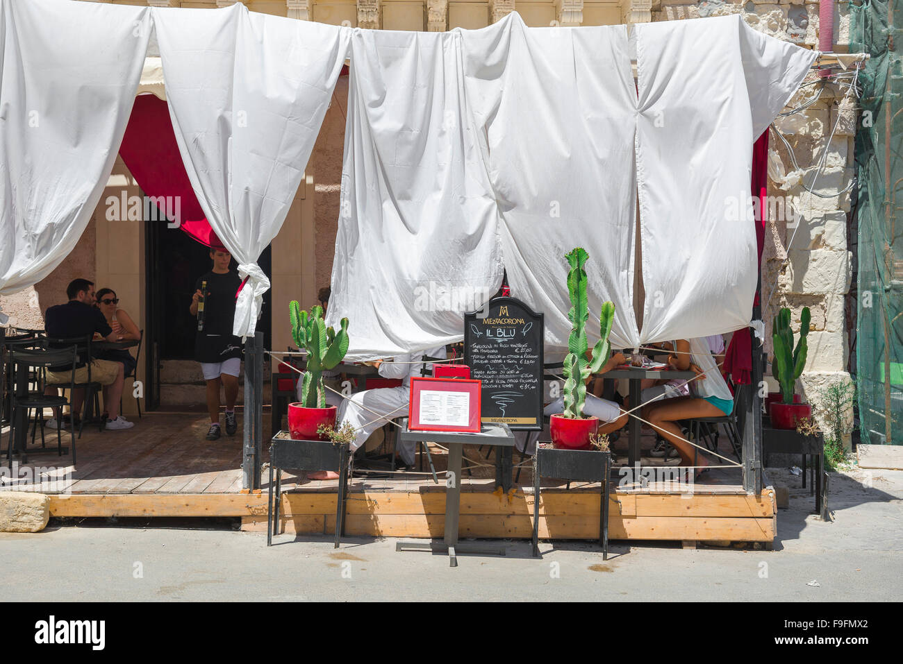 Sicily summer restaurant, sheets hoisted above a terrace provide shade for restaurant customers on a hot summer afternoon in Ortigia, Syracuse,Sicily. Stock Photo