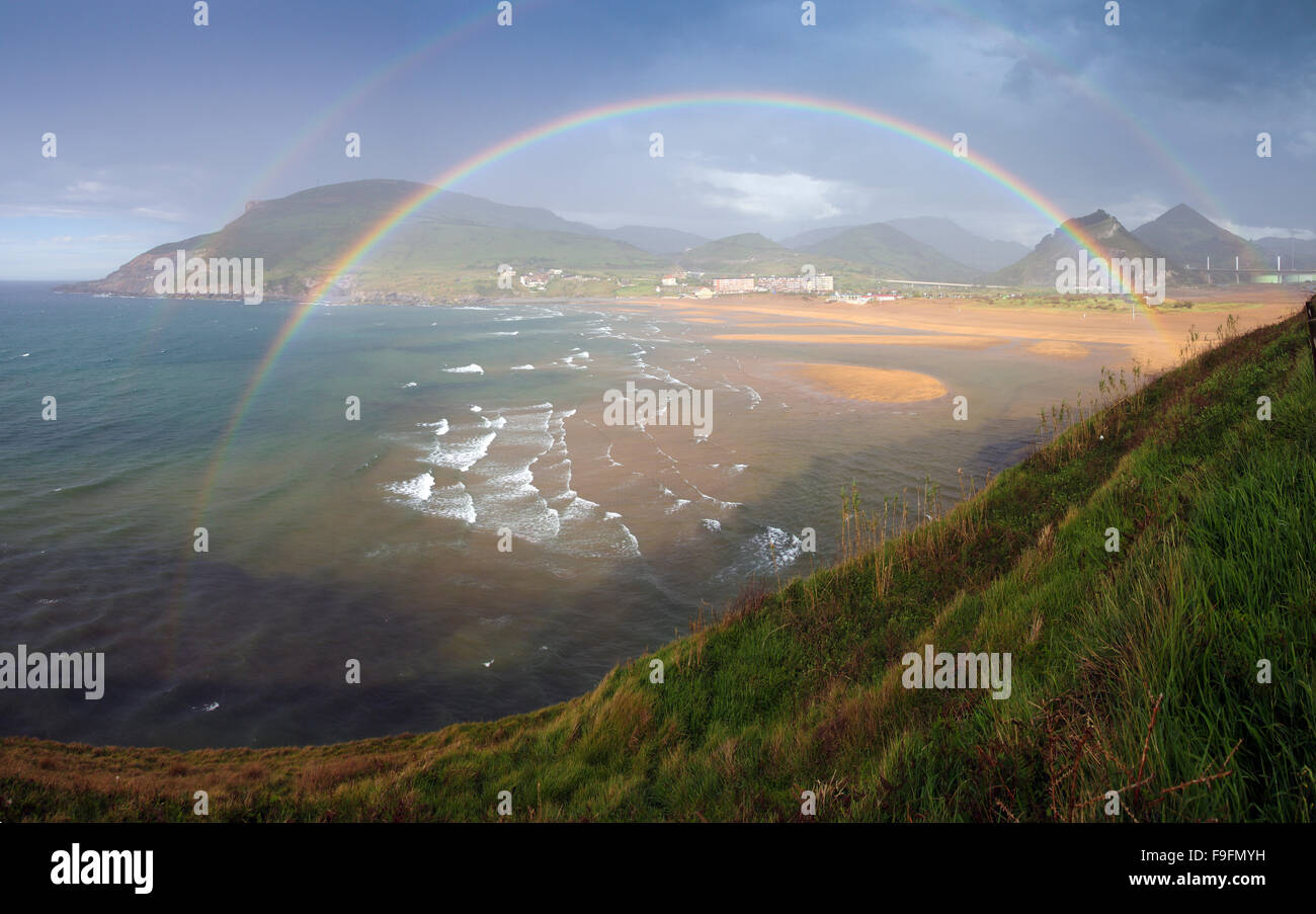 Rainbow in La Arena beach, Basque Country Stock Photo