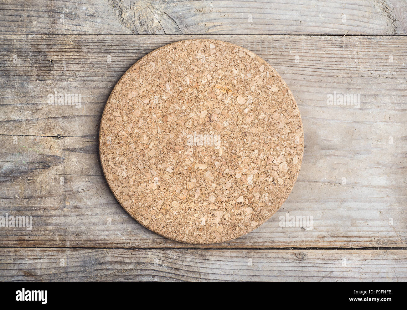 Round cork mat on wooden floor background Stock Photo