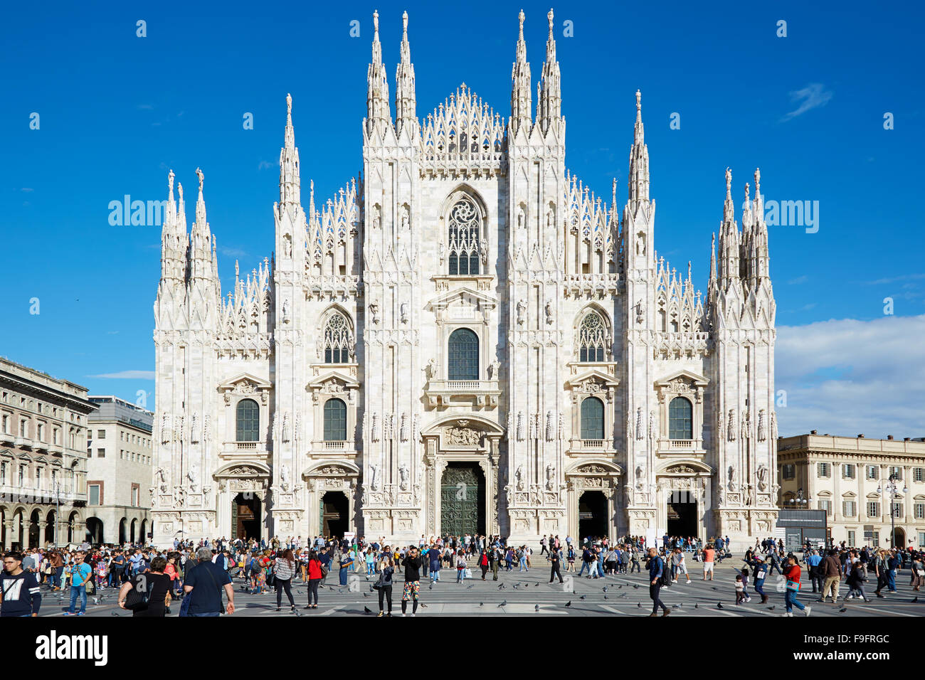 Milan Duomo, gothic cathedral facade and people passing in a sunny summer afternoon Stock Photo