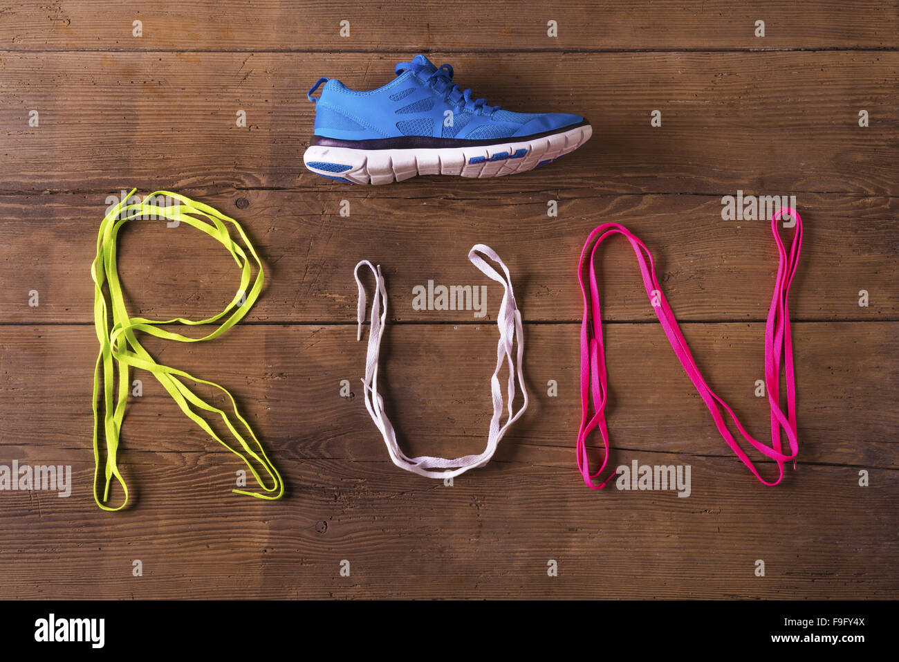 Running shoe and shoelaces run sign on a wooden floor background Stock Photo