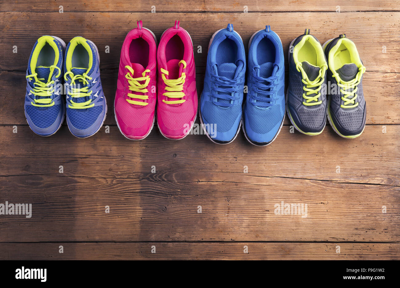 Four pairs of various running shoes laid on a wooden floor background Stock  Photo - Alamy