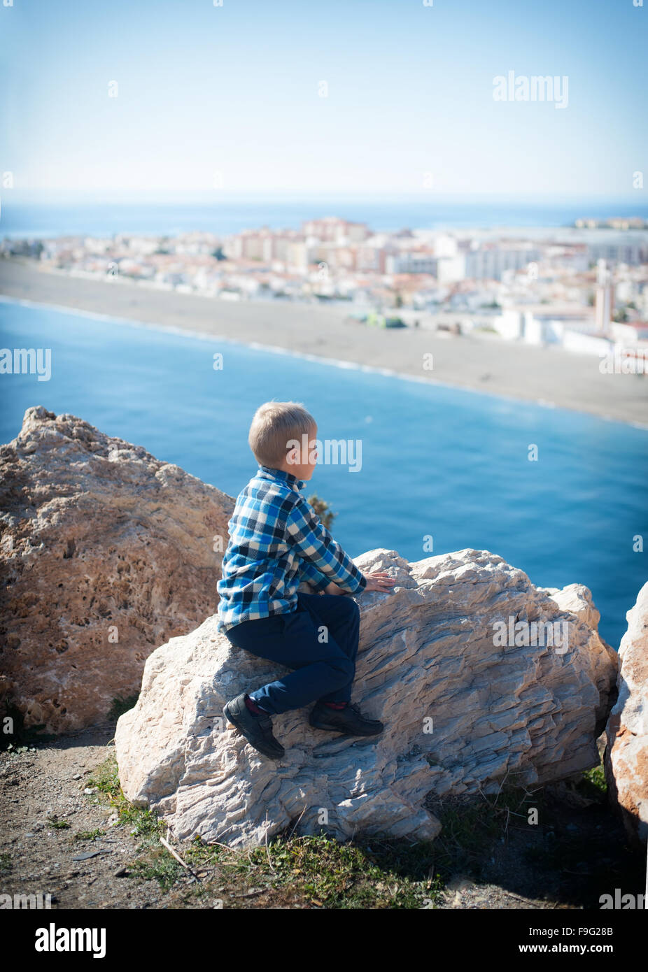little boy looking out to sea from high Stock Photo