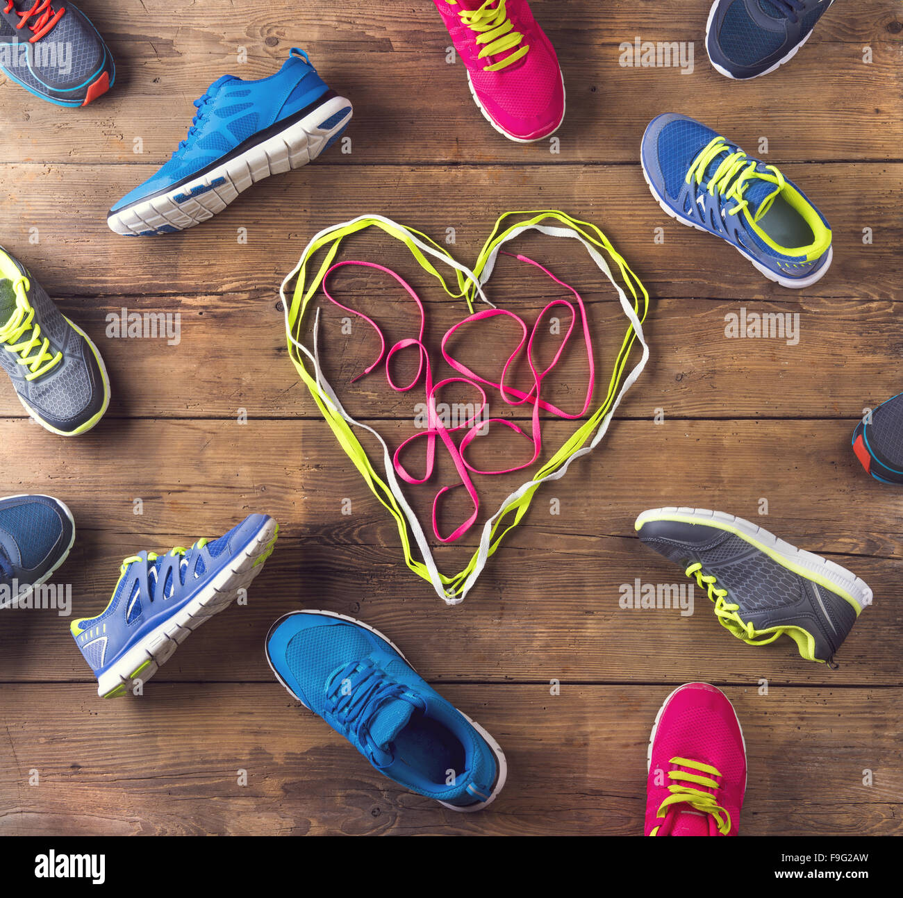 Various running shoes land shoelaces heart on a wooden floor background Stock Photo