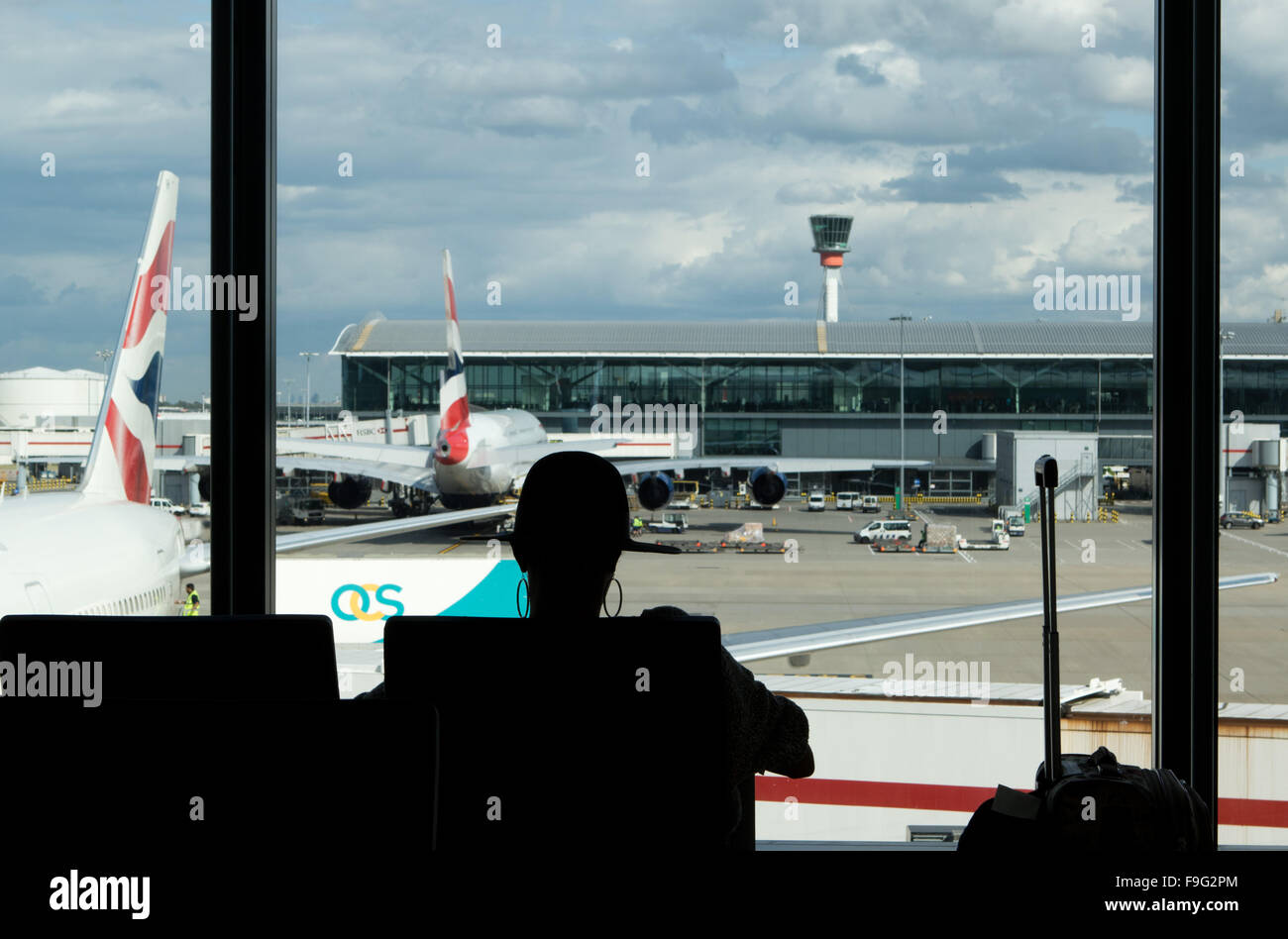 Silhouette of a female passenger sitting by the window.   travel - Heathrow airport -  London -  - Great Britain  - 28 A Stock Photo