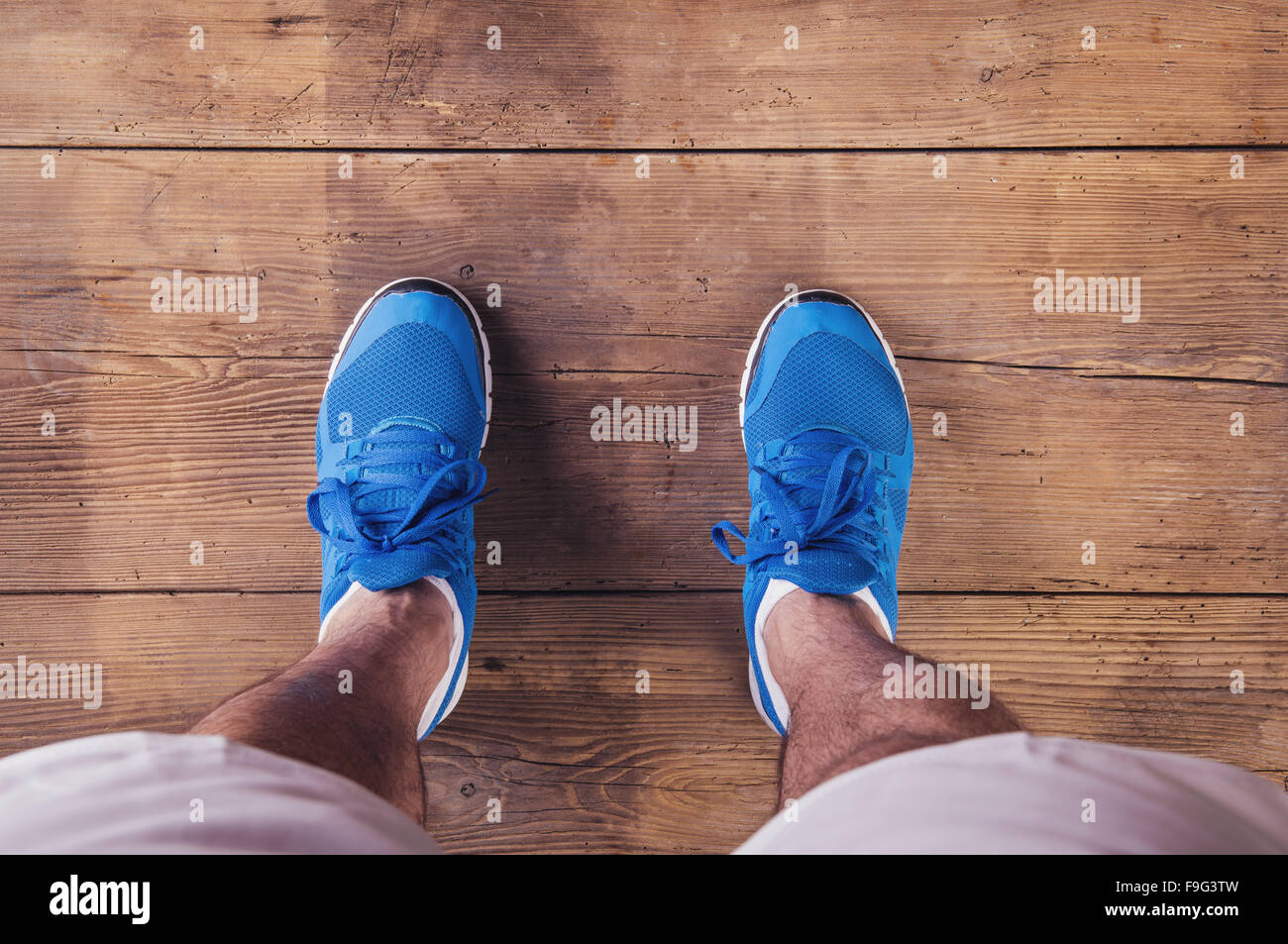 Legs of a runner on a wooden floor background Stock Photo