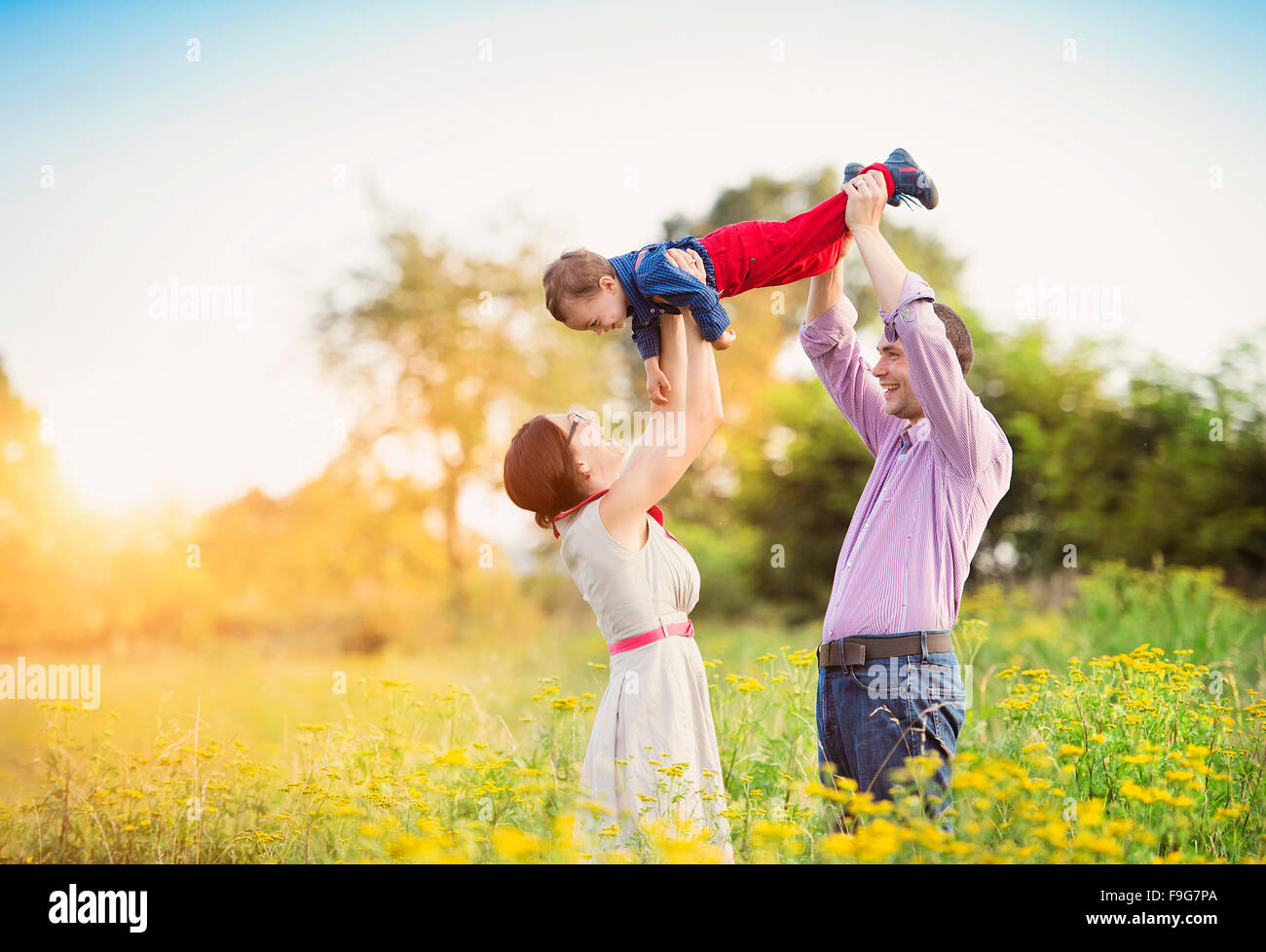 Happy young family having fun outside in summer nature Stock Photo